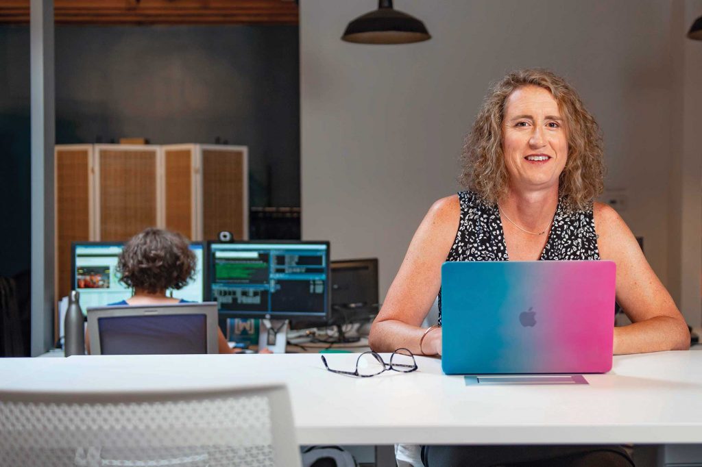 a woman sitting at a desk with a laptop