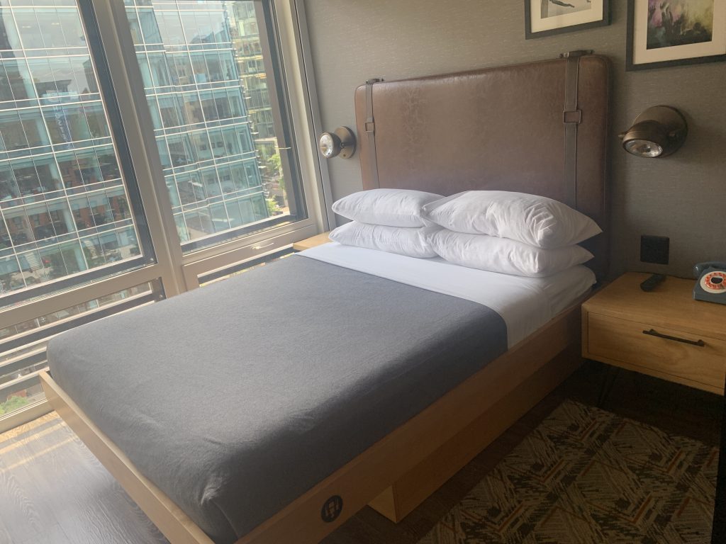 a bed with pillows and a window