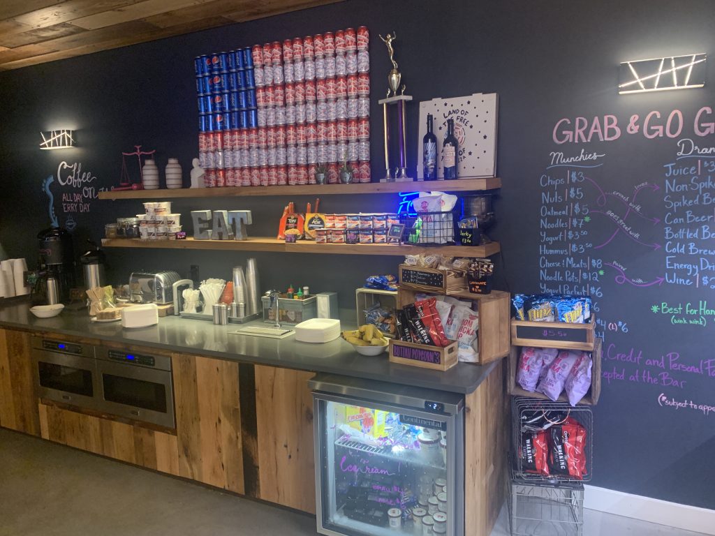 a counter with drinks and a chalkboard on the wall