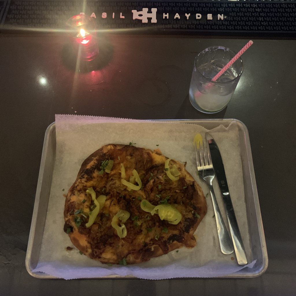 a pizza on a tray with a fork and knife