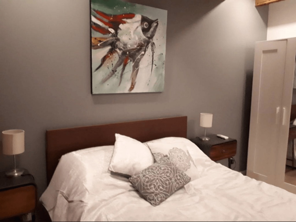 a bed with pillows and a painting on the wall