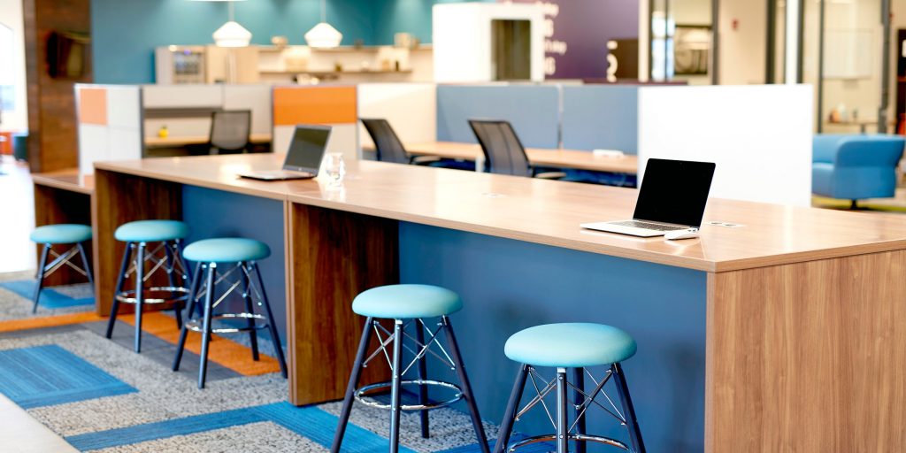 a laptops on a long table in an open space office