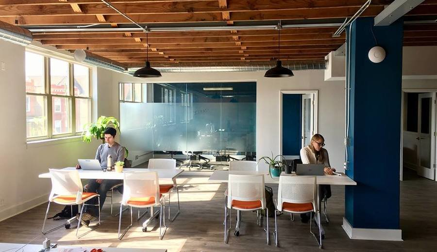 a group of people sitting at tables in an office