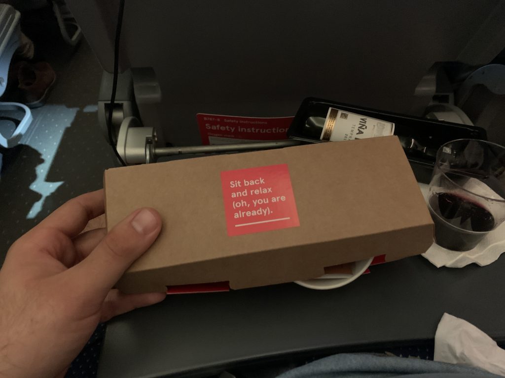 a hand holding a box with a red sticker