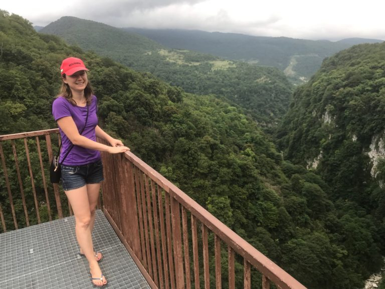 a woman standing on a deck overlooking a valley