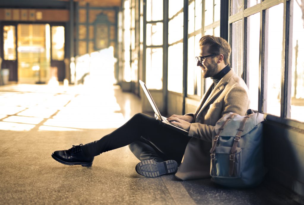 a man sitting on the floor with his laptop