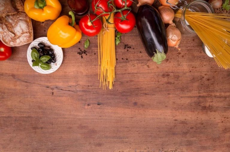 a table with different vegetables and pasta