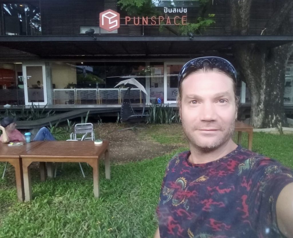 a man taking a selfie in front of a building