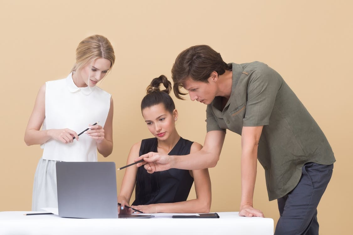 a group of people looking at a laptop