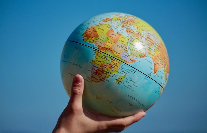 a hand holding a globe