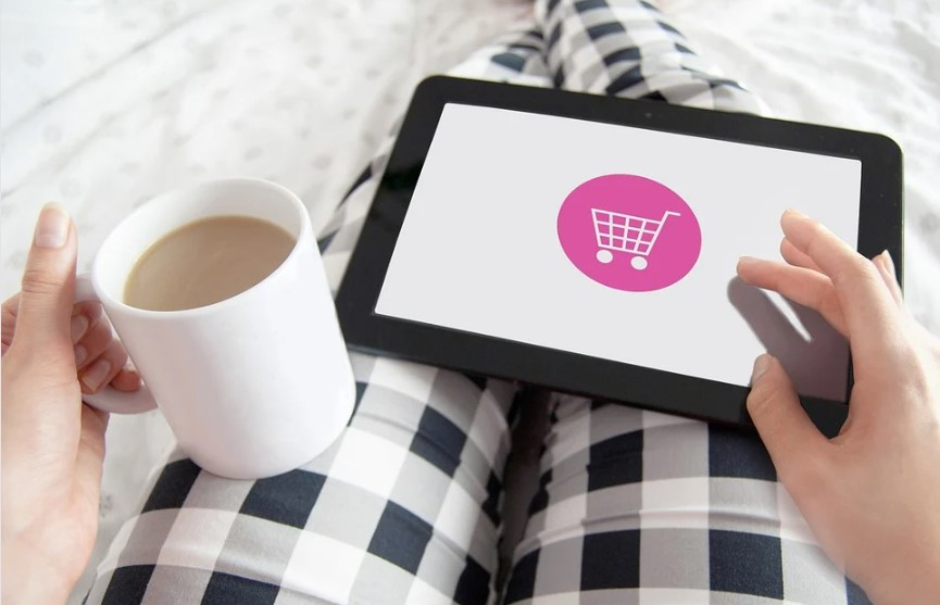 a person holding a tablet and a cup of coffee