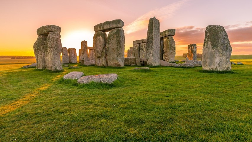 a stonehenge with a sunset in the background