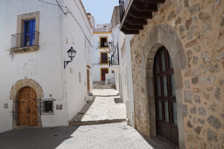 a street with buildings and a stone archway