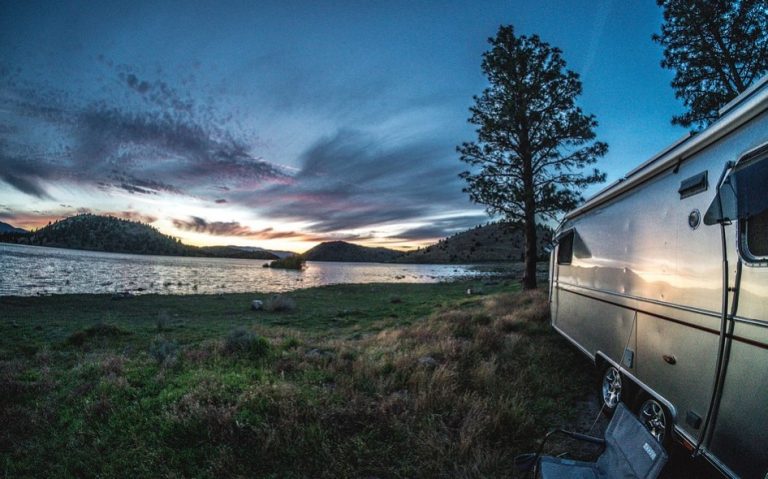 a camper parked next to a lake