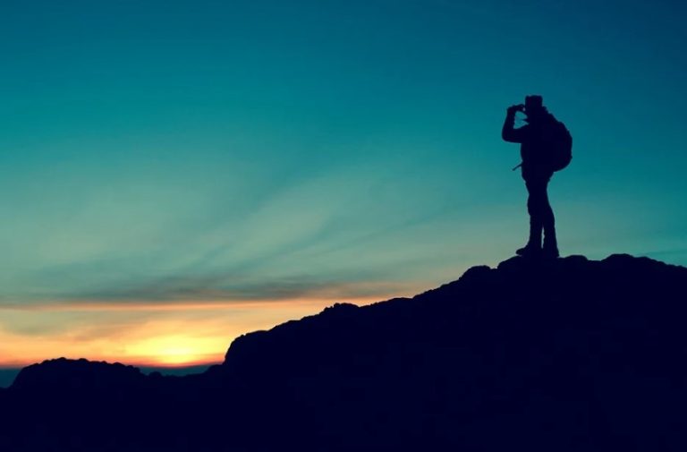 a silhouette of a person on a mountain