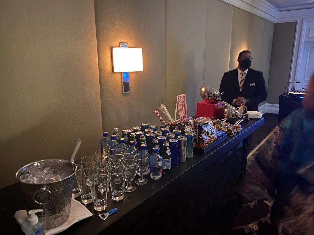 a man standing behind a bar with drinks and glasses