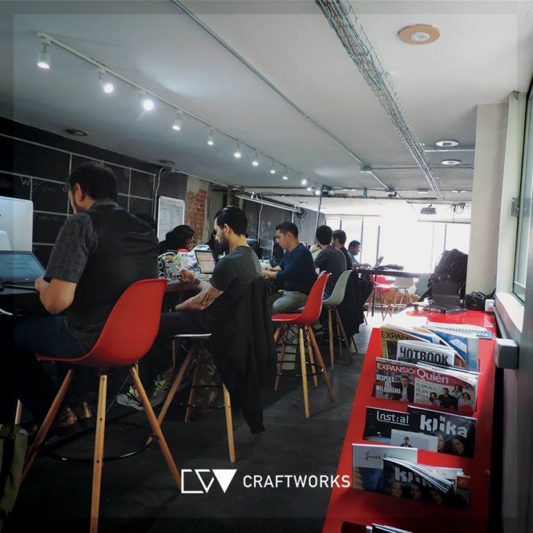 a group of people sitting at tables with computers