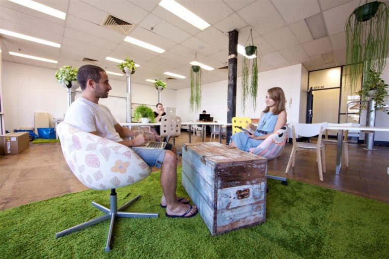 a man and woman sitting in chairs with a laptop