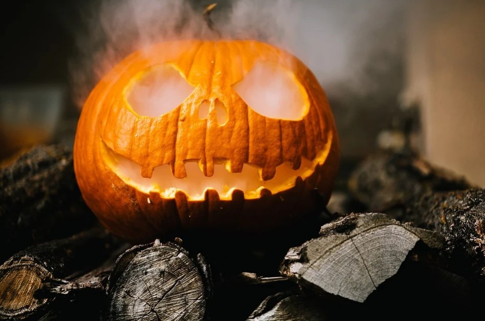 a carved pumpkin with a face and smoke coming out of it