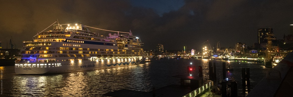 a cruise ship in a harbor at night