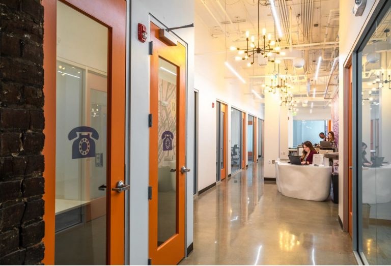 a group of people in a room with orange doors