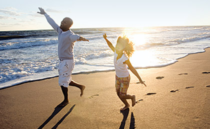 a man and woman running on a beach