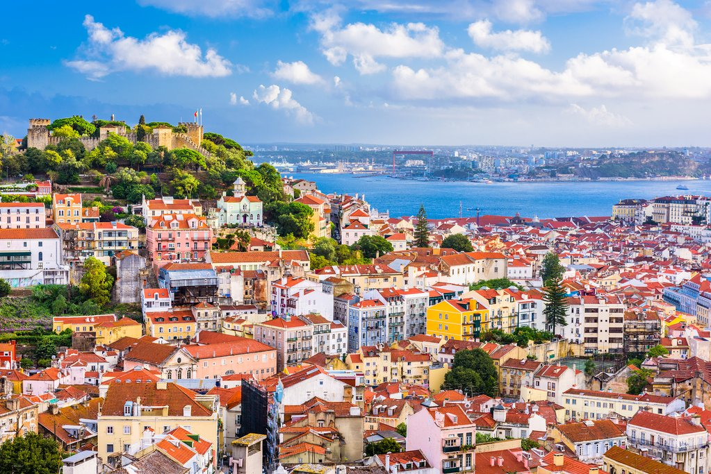 a city with red roofs and a body of water