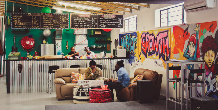 a group of people sitting in a room with graffiti on the walls