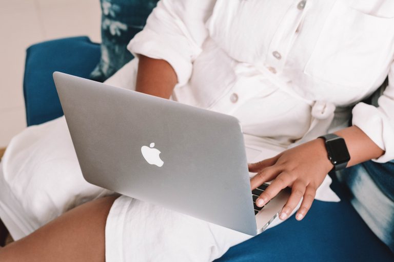 a person sitting on a couch using a laptop