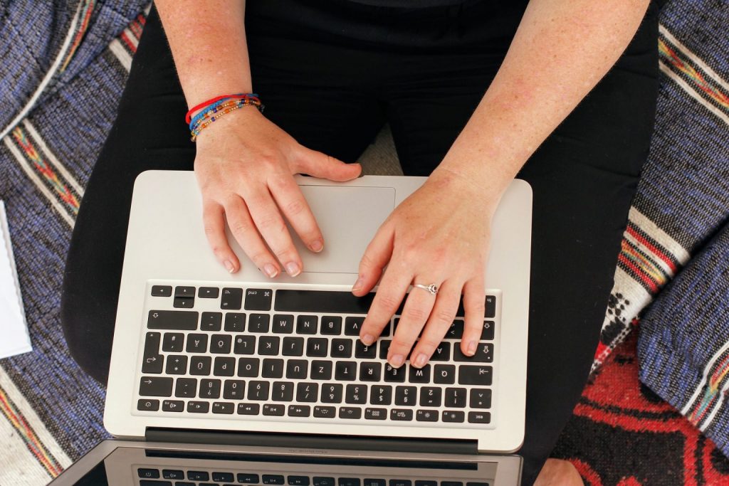 a person sitting on the floor using a laptop