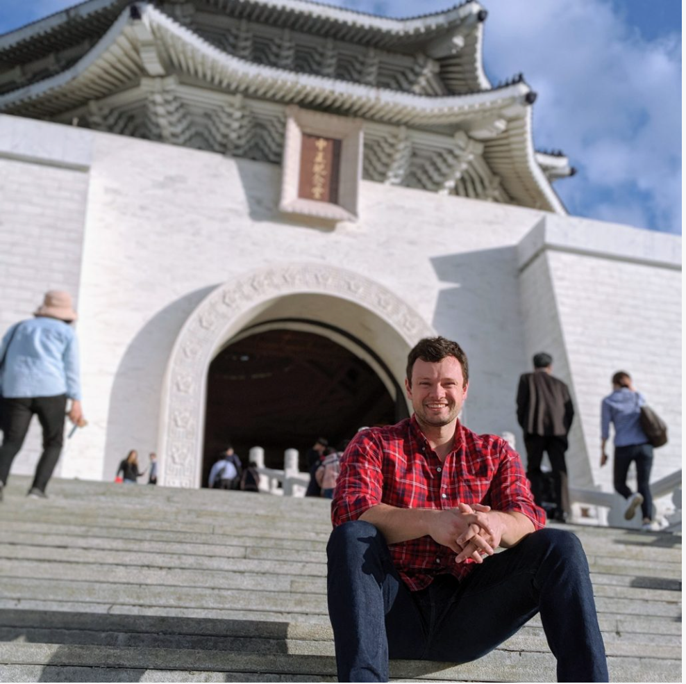 a man sitting on stairs in front of a building