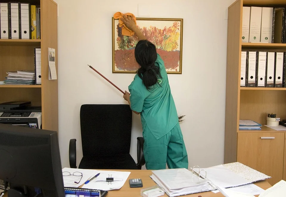 a woman cleaning a picture on the wall